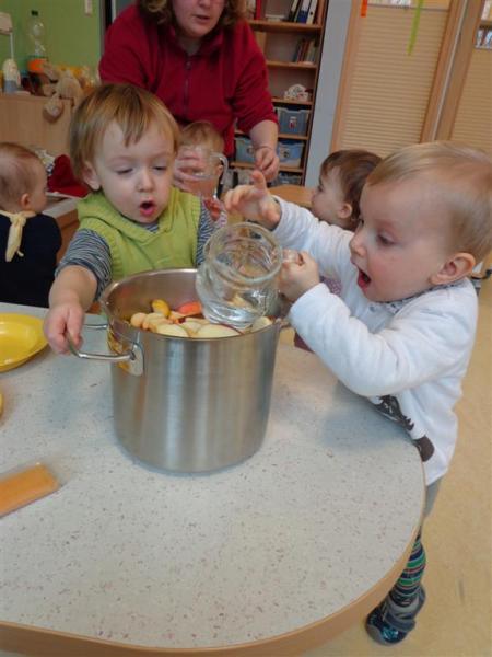 Krippenkinder bei der Arbeit an Obst in einem Topf